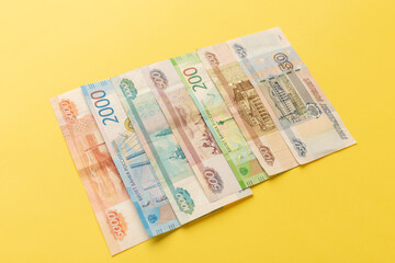 Money of Russia. Banknotes and coins on yellow background. Close-up of Russian rubles of various denominations. Finance concept