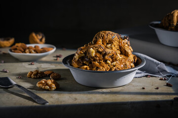 Ice cream with chocolate, nuts and almonds served in metal bowl on wooden table
