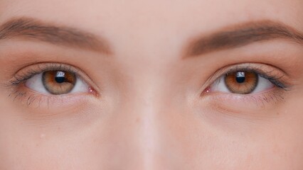 Obraz premium Macro close-up shot of young brunette woman opens her eyes and looks at camera