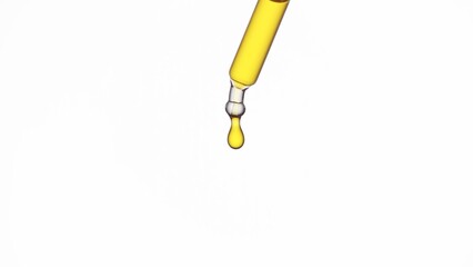 Drop of yellow transparent liquid is hanging from lab dropper on white background | Abstract face...