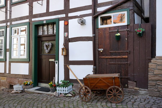 Alter Leiterwagen aus Holz auf altem Kopfsteinpflaster vor einem sch&ouml;nen alten Fachwerkhaus in der Weinberggasse in der Altstadt von Blomberg in Ostwestfalen-Lippe