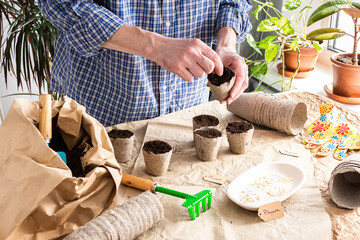 The process of planting sweet pepper seeds in peat eco friendly forms, a bag of earth and garden...