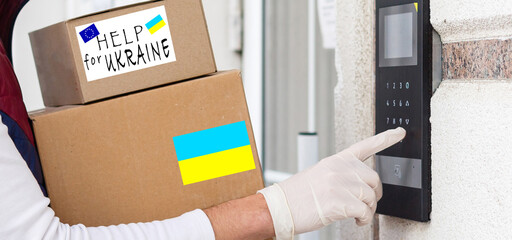 Close up of volunteer cyrrying box with Humanitarian aid for Ukrainian refugees in street