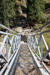 pedestrian steel bridge over the mountain river