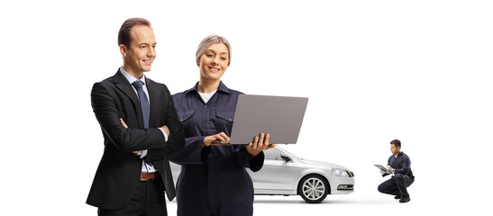 Male customer and a female car mechanic looking at a laptop computer