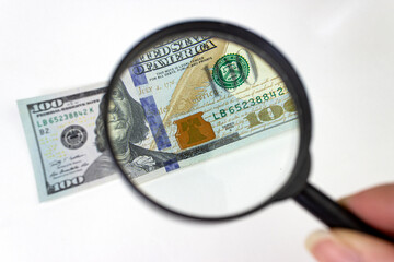 Magnifying Glass - 100 US Dollars. Hundred dollar bill under a magnifying glass.