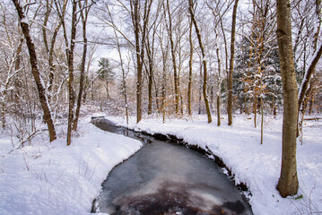 Frozen river through a snowy forest in Franklin, Connecticut