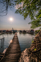 Fishing houses, holiday home, wooden house in the lake with jetty. Bokod Hungary Bora Bora landscape with sunset
