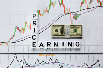 Price and Earning written on cube with candle stick chart background. Investment concept for P/E ratio.