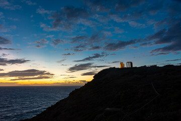 Beautiful sunset over the cliff of The Temple of Poseidon at Cape Sounion, over the Aegean Sea Greece