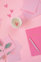 Elegant, aesthetic feminine workspace with office supply items on pink background. Paper clips in shape of hearts.