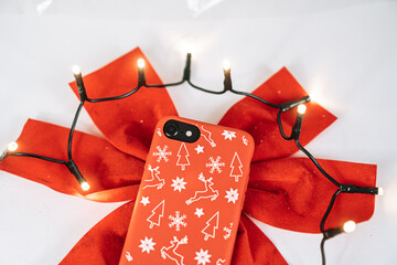 Closeup of Christmas ornaments and a phone with a red case