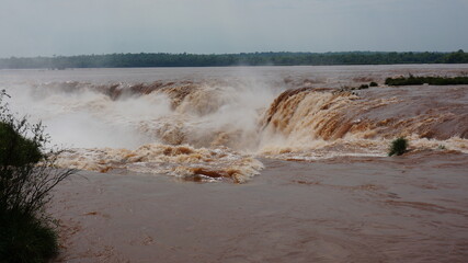 waterfalls of iguazu during flood brown water