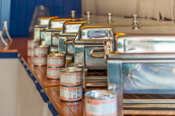 Closeup of metal buffet containers with cans