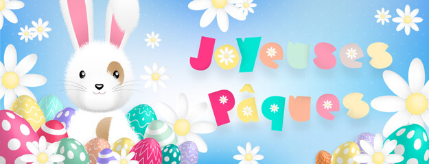Texte «Joyeuses Pâques» aux couleurs pastels, avec un mignon lapin blanc derriere des oeufs colorés et des fleurs sur un fond bleu