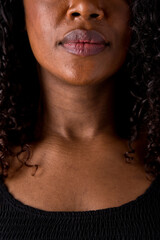 Close up portrait of african american woman features and soft dark caramel skin. Vertical front view of unrecognizable woman lips and nose. People and diversity concept.