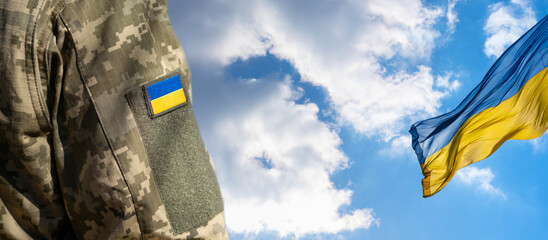 Ukrainian flag on a military uniform on a blue sky, war. Soldier Armed Forces of Ukraine....