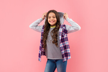 smiling kid with curly hair on pink background, casual fashion
