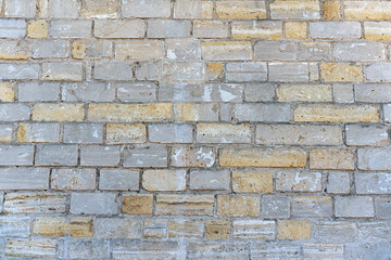 Old brick wall made of limestone stones of different sizes as a natural background