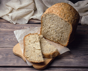 Homebaked bread sourdough  bread with seeds cut into slices lies on a cutting board. Loaf of bread , healthy breakfast.