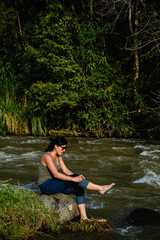 young latina city woman at the river reconnecting with nature and the environment. copy space, vertical photo