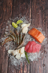 Fresh fish and seafood arrangement on crushed ice on a wooden table