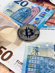 Pièce bitcoin et billets euros 