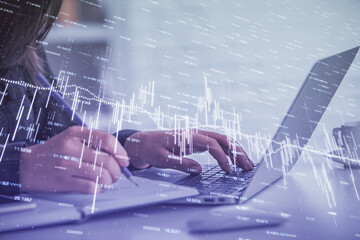 Double exposure of businesswoman hands typing on computer and forex graph hologram drawing. Financial analysis concept.