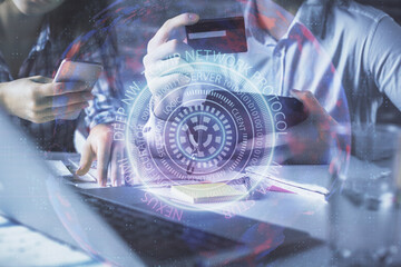 Fototapeta premium Double exposure of man and woman on-line shopping holding a credit card and tech theme hologram drawing. Technology concept.