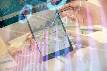 Double exposure of man's hands holding and using a phone and financial chart drawing. Market analysis concept.