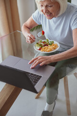 Senior woman having tasty breakfast at home