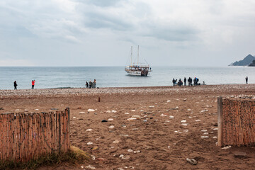 Fototapeta na wymiar Mediterranean coast, wooden fence and ship.