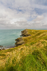 Grassy headland or peninsula with coastguard lookout in distance, portrait, , copyspace at top
