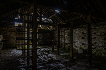 Abandoned industrial room with empty racking in near darkness
