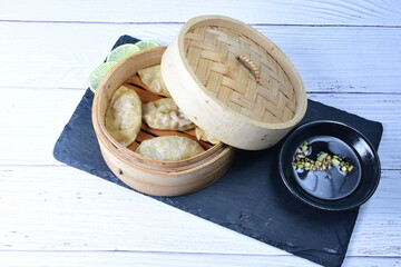 Steamed gyozas, oriental empanada, stuffed with meat, spices, onion, lemon and sauce