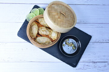 Steamed gyozas, oriental empanada, stuffed with meat, spices, onion, lemon and sauce