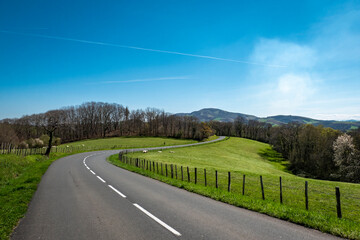 Estrada entre Villefranque e Hasparren no País Basco com uma paisagem verde e um céu azul