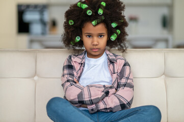 African american girl looking at camera sitting on sofa