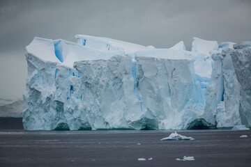 Beeindruckend, ein gigantischer Eisberg türmt sich im antarktischen Meer auf und erstrahlt in...