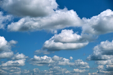 Bright landscape of white puffy cumulus clouds on blue clear sky