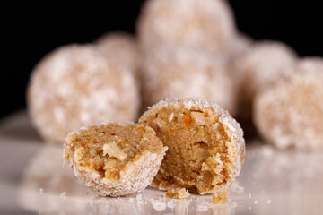 Beautiful sweets with coconut on a white plate on a black background