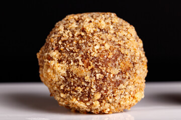 Beautiful candy truffle on a white plate on a black background