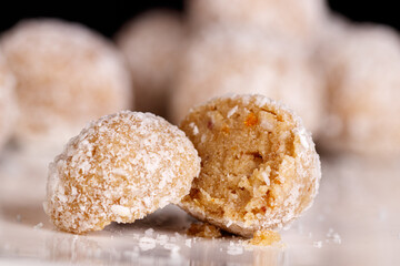 Beautiful sweets with coconut on a white plate on a black background