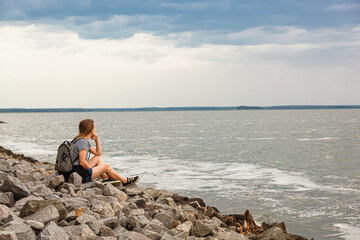 Beautiful girl on the sea with blue sky and clouds
