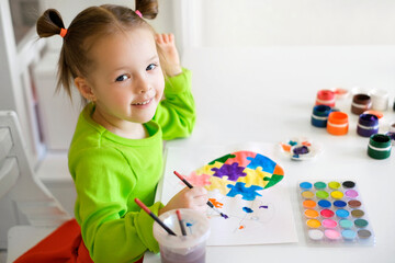 A beautiful little girl looks into the camera smiling sweetly. A child spends time drawing a...