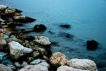 Fototapeta na wymiar Transparent blue waters of the Adriatic sea washing a shore full of unusual beautiful stones in Pedaso
