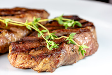 Grilled marbled beef steak lies on a white plate