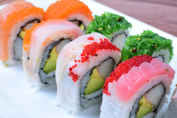 Traditional colorful suhi, cream cheese, salmon, caviar, rool sishi crunch, sesame seeds and sauce