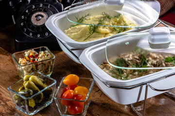 Stroganov beef, a traditional dish of Russian and Soviet cuisine and mashed potatoes, is on the table with an old phone.