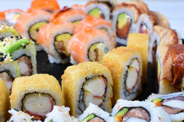 Traditional colorful suhi, cream cheese, salmon, caviar, rool sishi crunch, sesame seeds and sauce